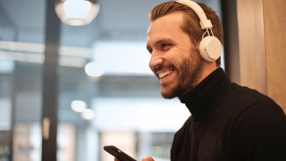 Man listening to songs wearing a headphone things to do before going to a concert